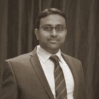 Portrait of Aniruddha Harne, OMPEG Core Group, in a suit and tie.