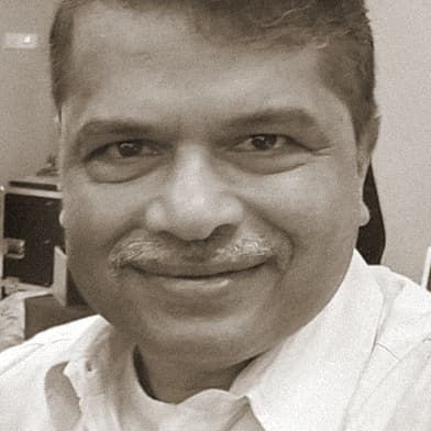 Portrait of Dr Mahadeo Bhide, OMPEG Core Group, smiling.